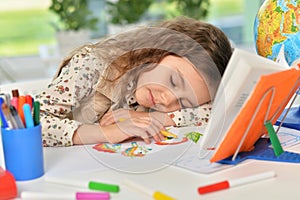 Portrait of cute schoolgirl sleeping on table