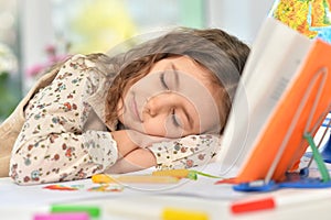 Portrait of cute schoolgirl sleeping on table