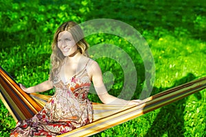 Portrait of Cute And Sensual Caucasian Blond Girl Relaxing In Hammock In Green Forest Outdoors
