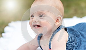 Portrait of cute smiling baby girl, outdoors, light effect