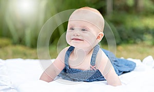 Portrait of cute smiling baby girl, outdoors, light effect