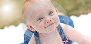 Portrait of cute smiling baby girl, outdoors, light effect