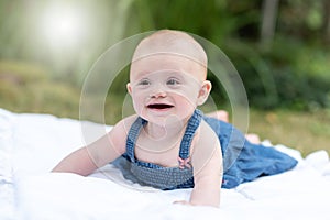 Portrait of cute smiling baby girl, outdoors, light effect