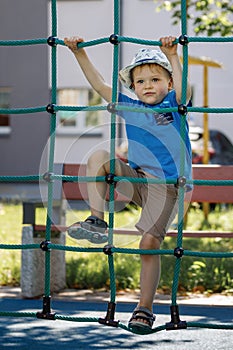 Little boy, playground and climbing rope tower