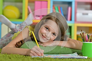 Portrait of cute smiling girl drawing at home