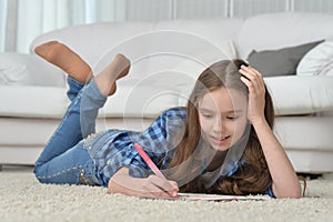 Portrait of cute smiling girl drawing at home