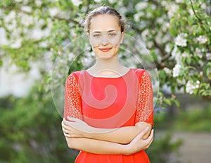 Portrait cute smiling girl in red dress in nature