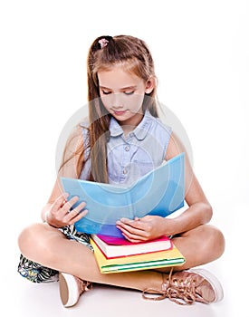 Portrait of cute smiling happy little school girl child teenager sitting on a floor and reading the book isolated