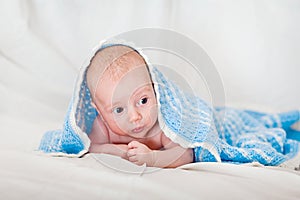 Portrait of a cute smiling infant baby crawling in a diaper, two-month baby child holds head
