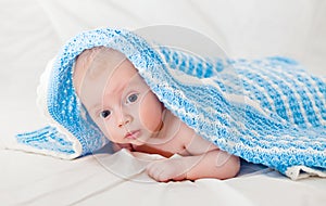 Portrait of a cute smiling infant baby crawling in a diaper, two-month baby child holds head