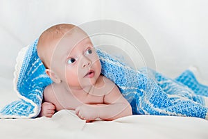 Portrait of a cute smiling infant baby crawling in a diaper, two-month baby child holds head