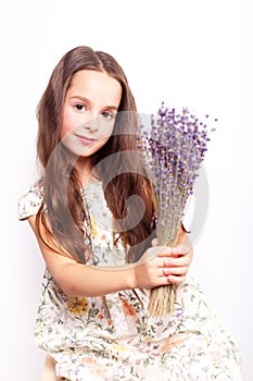 Portrait of cute smiling little girl with bunch of lavender flowers