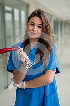 Portrait of a cute smiling young nurse in a blue uniform during a coronavirus epidemic