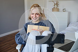 Portrait of cute, smiling young social media content creator, girl records video on digital camera and stabiliser, holds