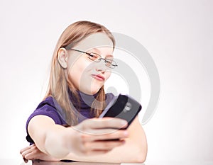 Portrait of a cute teen girl with phone taking selfie