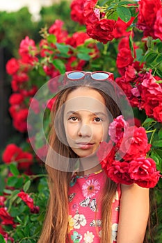 Portrait of cute teen girl smiling at the roses