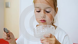 portrait of a cute teenage girl eating cream ice cream holding a glass ice cream maker on her leg and a silver metal