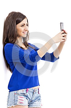 Portrait of cute teenage girl taking self portrait with her smart phone