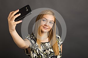 Portrait of cute teenage girl taking selfie with her smart phone