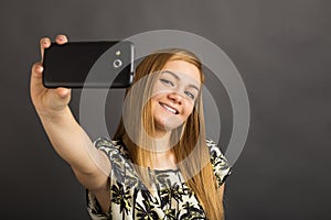 Portrait of cute teenage girl taking selfie with her smart phone