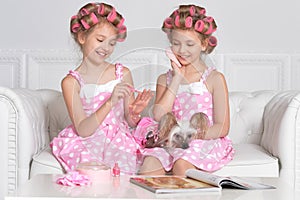 Portrait of cute tweenie girls with hair curlers sitting