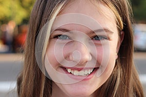 Portrait of a cute white teen girl on blurred summer green city background