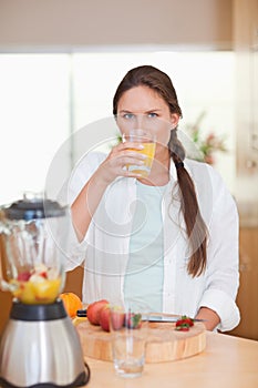 Portrait of a cute woman drinking fresh fruits juice