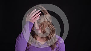 Portrait of cute woman gesturing facepalm showing annoyance and irritation on black background.