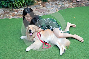 Portrait of cute woman playing with dog on green grass
