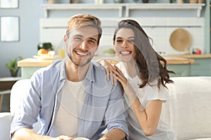 Portrait of cute young couple sitting in sofa