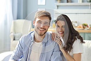 Portrait of cute young couple sitting in sofa