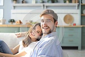 Portrait of cute young couple sitting in sofa