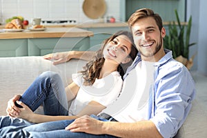 Portrait of cute young couple sitting in sofa