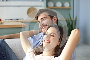 Portrait of cute young couple sitting in sofa