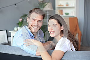 Portrait of cute young couple sitting in sofa