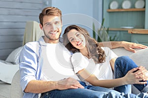 Portrait of cute young couple sitting in sofa