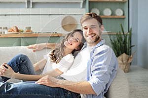 Portrait of cute young couple sitting in sofa