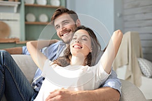 Portrait of cute young couple sitting in sofa