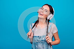 Portrait of cute young girl with funny pigtails in jeans overall