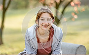 Portrait of cute young girl sitting in the park