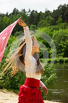 portrait of cutly cute girl dance with red Scarf at the river