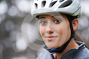 Portrait, cycling and helmet with sports woman closeup on blurred background in nature for fitness. Face, exercise and