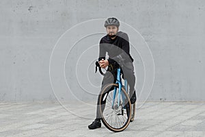 Portrait of a cyclist on a gravel bike on a gray urban background. Active lifestyle