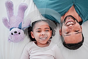 Portrait of dad, child and teddy bear on bed from above, bonding and love with play time to relax. Smile, happiness and