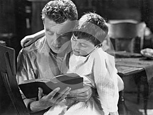 Portrait of dad reading bedtime story to son photo