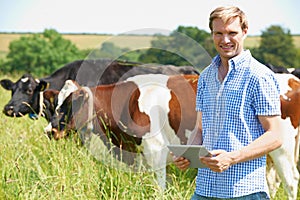 Portrait Of Dairy Farmer With Digital Tablet In Field