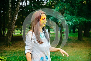 Portrait of dark long hair woman all in holi paints