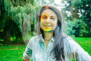 Portrait of dark long hair woman all in holi paints