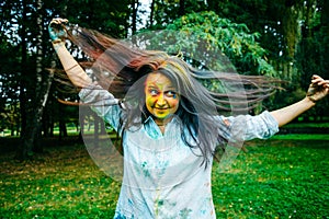 Portrait of dark long hair woman all in holi paints