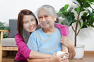 Portrait of a daughter with an elderly Asian mother smiling happily.